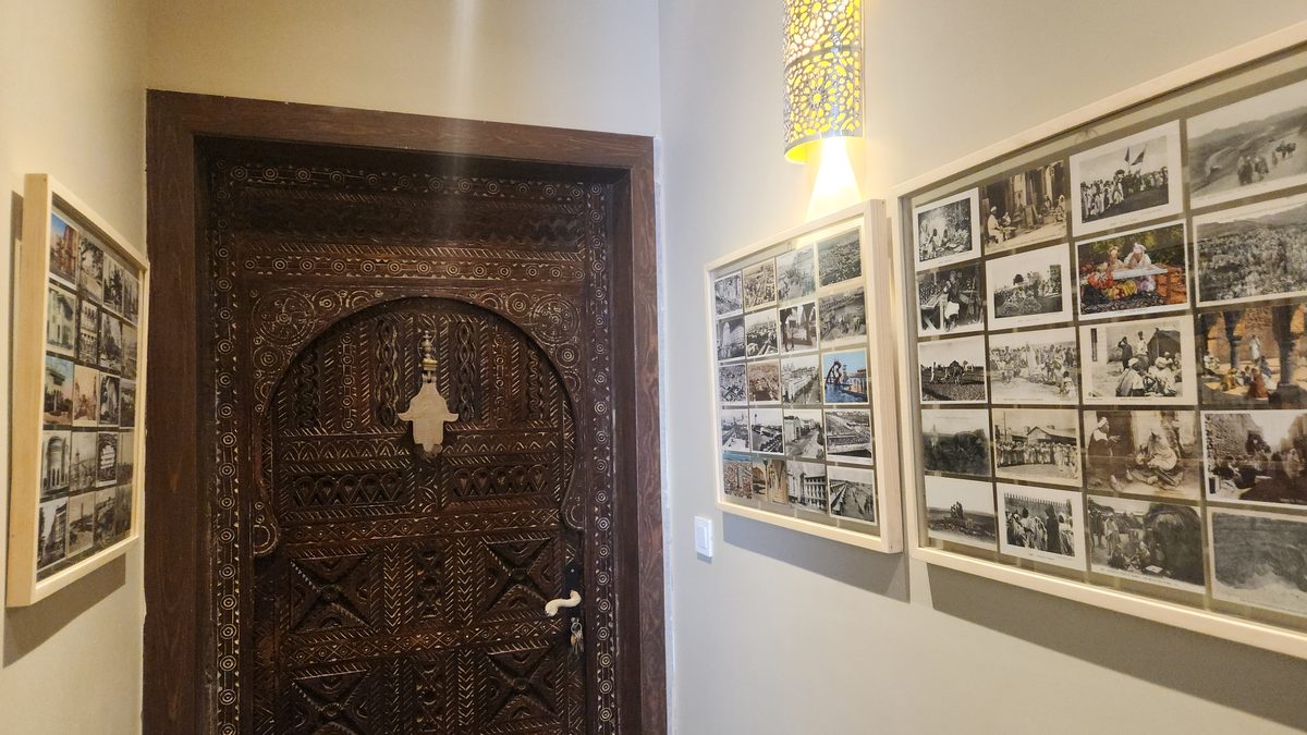 Le couloir des mémoires — cartes postales anciennes du Maroc et porte berbère sculptée à khamsa